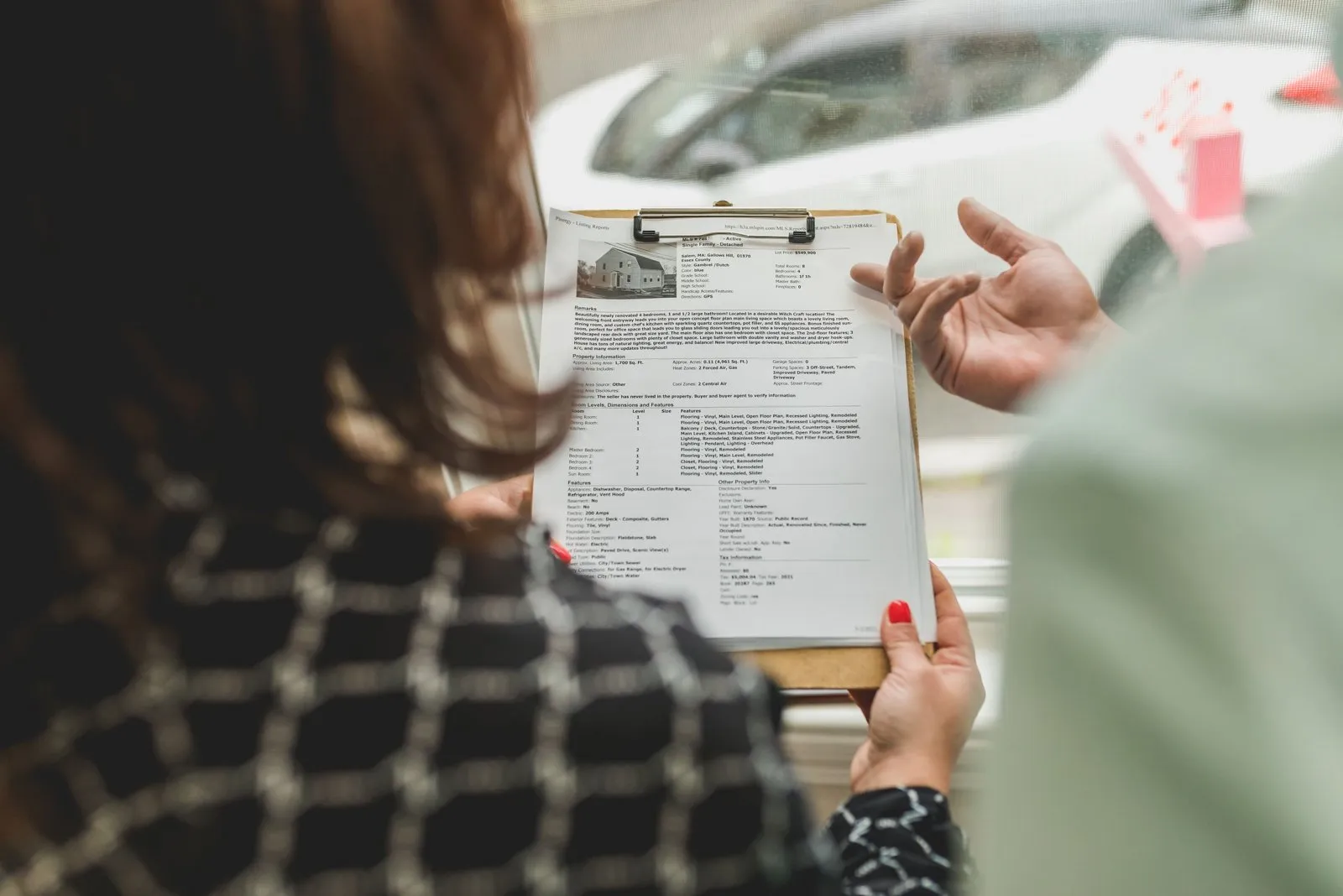 Une personne vérifie une annonce immobilière sur ordinateur avec calculatrice et documents
